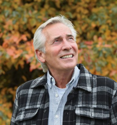 Mature male model in autumn portrait wearing checked jacket outdoors