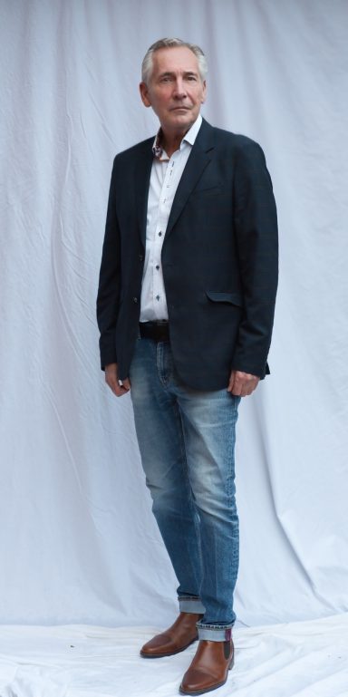 Mature male fashion model posing in smart jacket and shirt in studio 